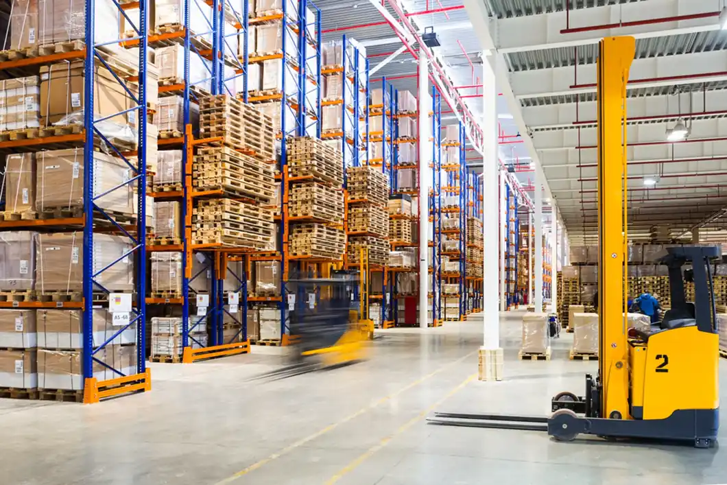 Pallet racking, stored goods and handling equipment inside a bright distribution warehouse