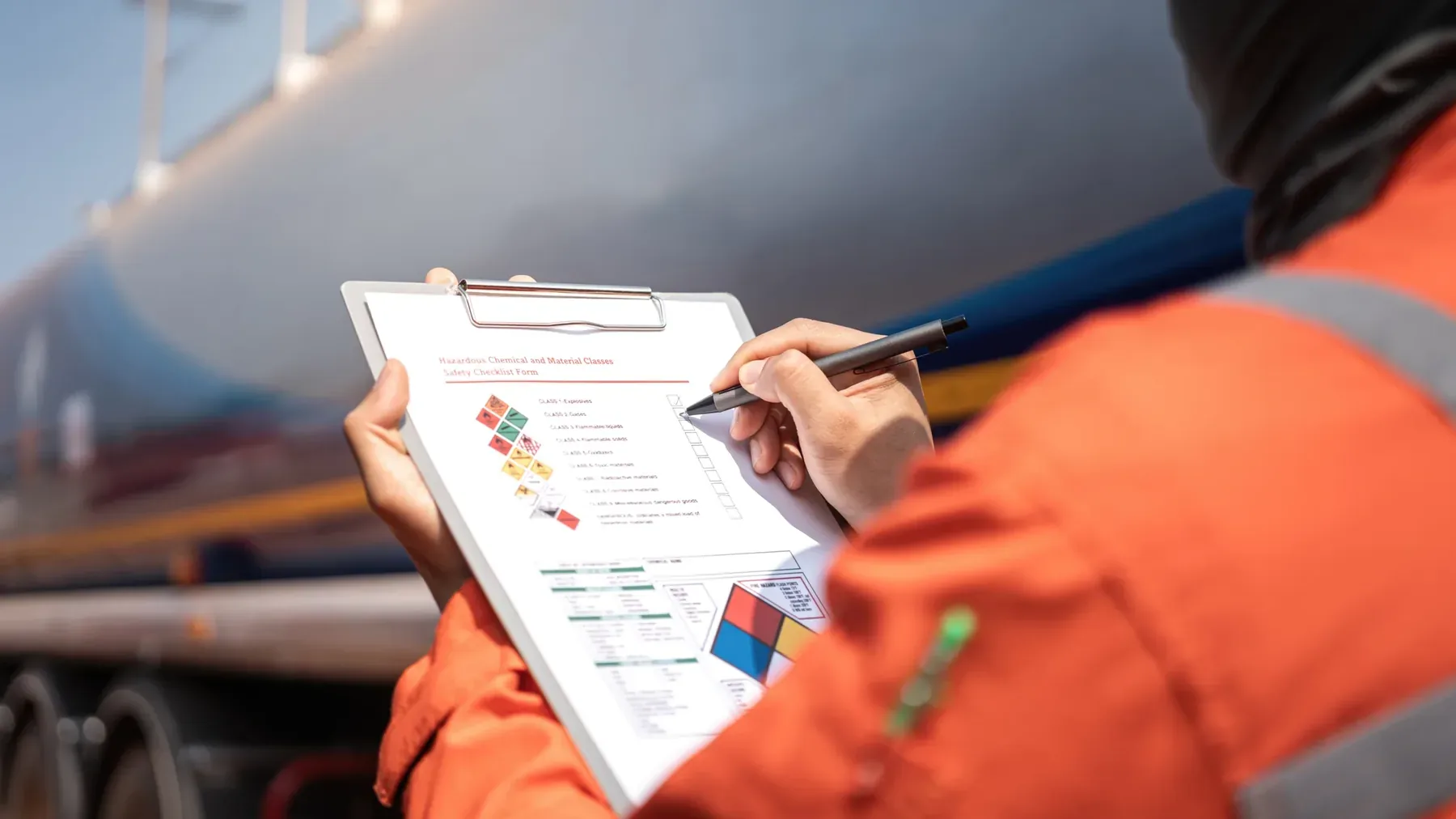 Person checking paperwork beside a tanker.