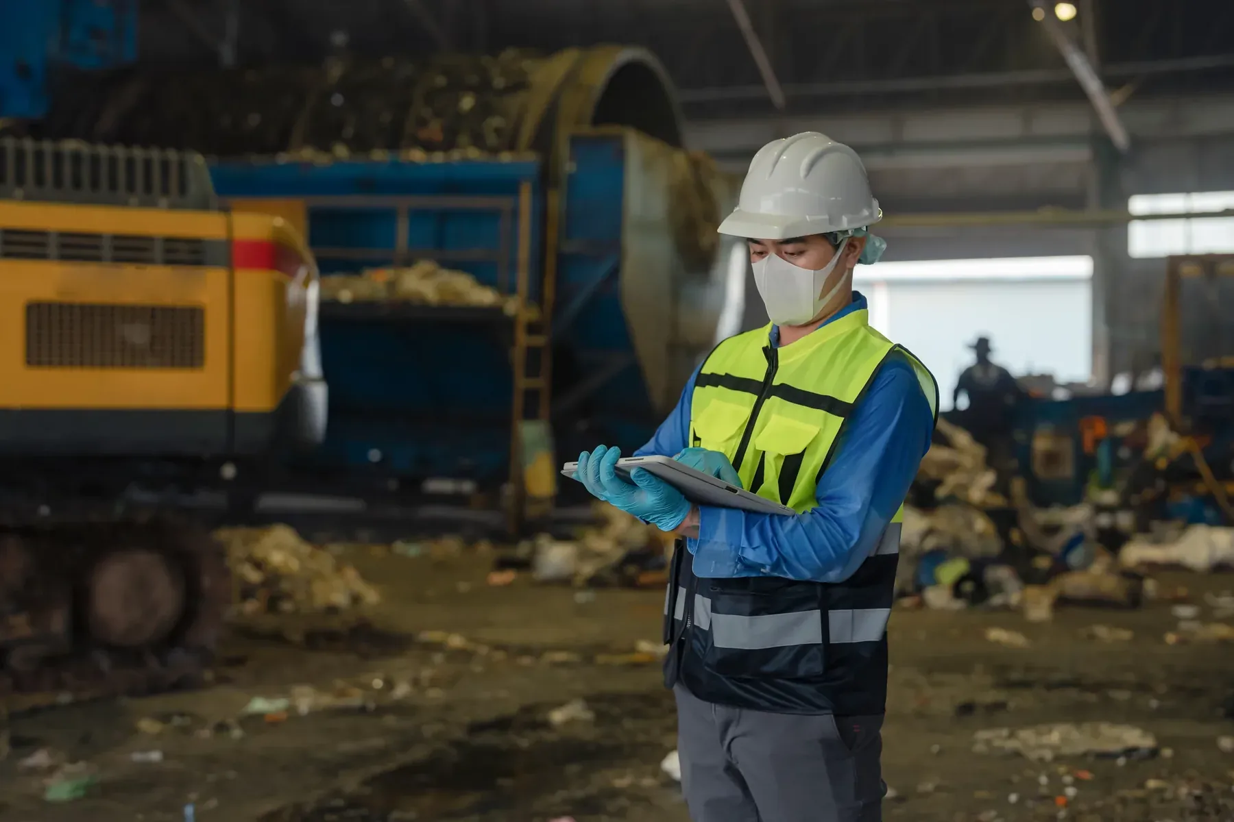 Person recording observations at a waste recycling facility.