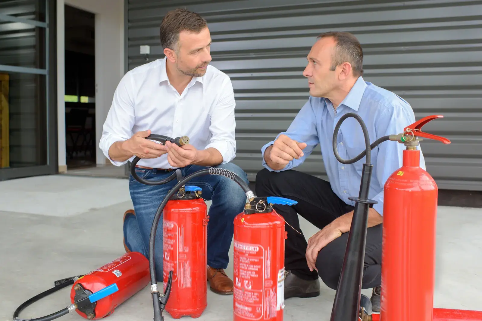 Inspecting a group of fire extinguishers in a workshop.