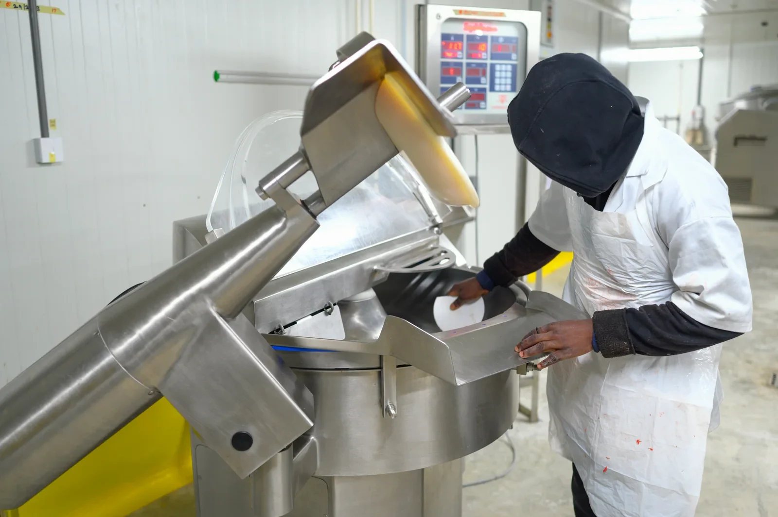 Worker cleaning the inside of a food processing machine.