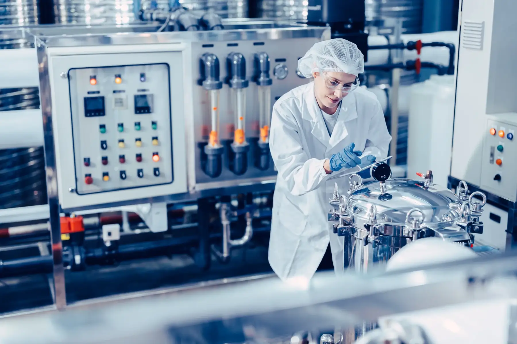 Food factory worker inspecting production equipment.