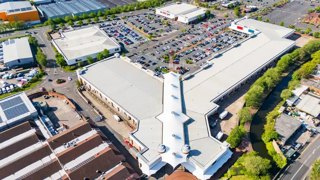 Aerial view of a retail park with shared car parks and service areas.