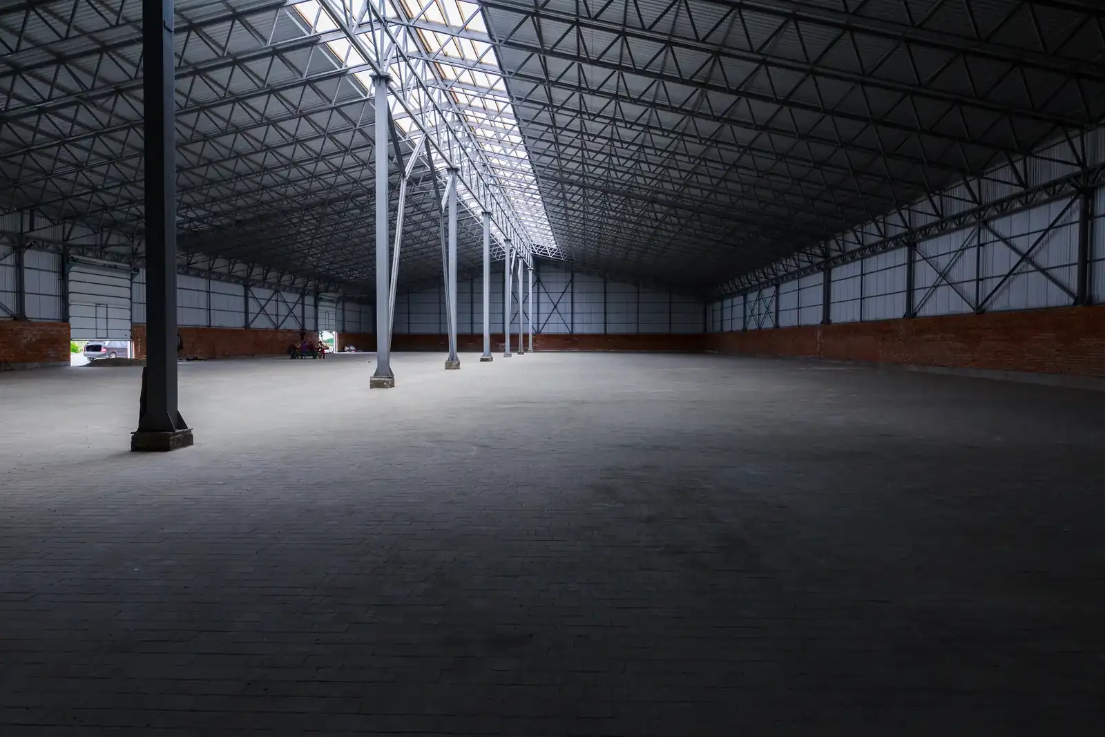Empty grain storage building with a clear floor and steel roof structure.