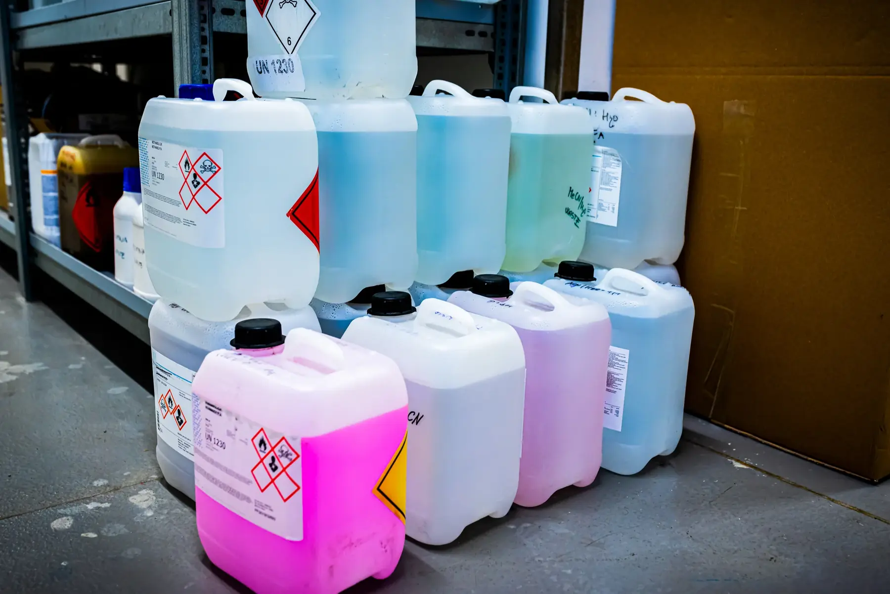 Plastic chemical containers with hazard labels.