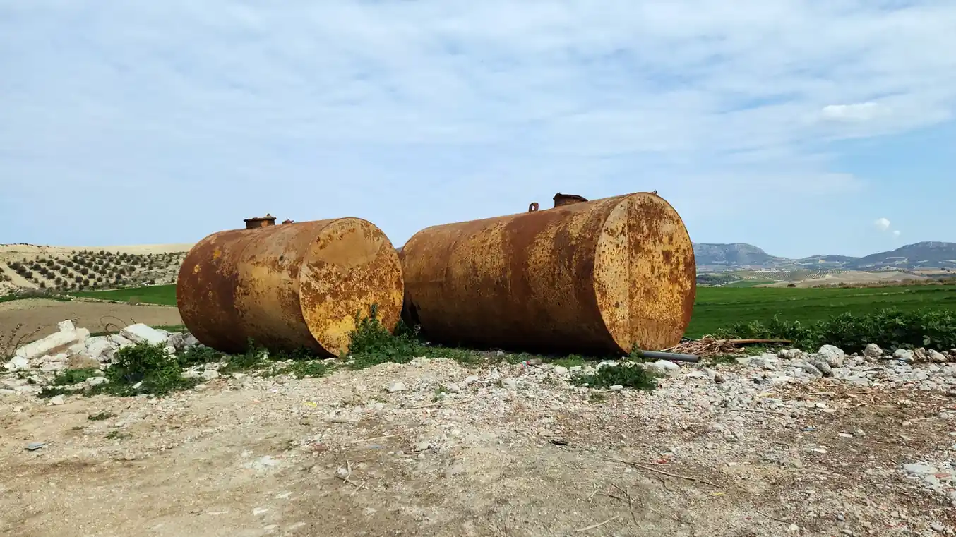 Removed steel fuel storage tanks in an outdoor work area.