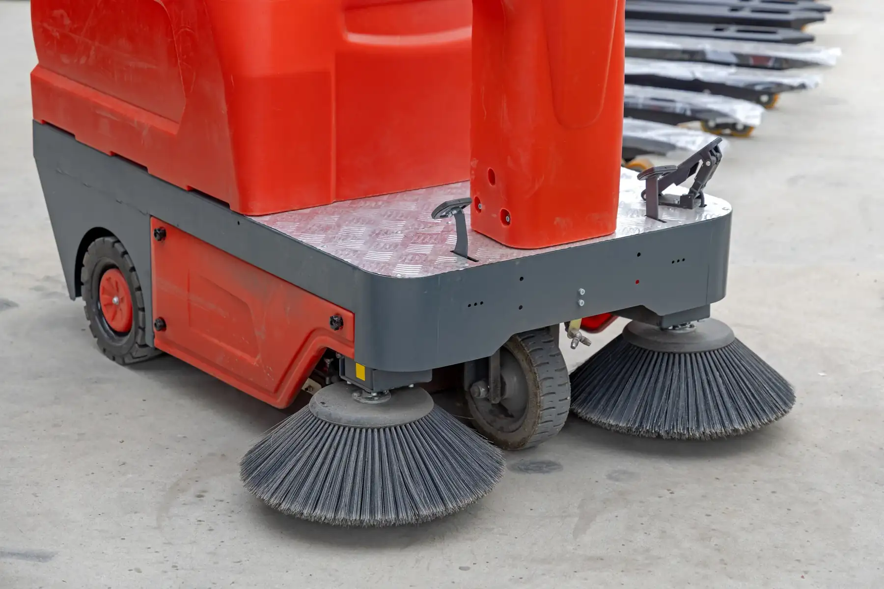 Brushes beneath a ride on floor sweeping machine.